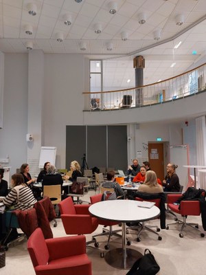 Valokuva ihmisistä keskustelemassa pienryhmissä.