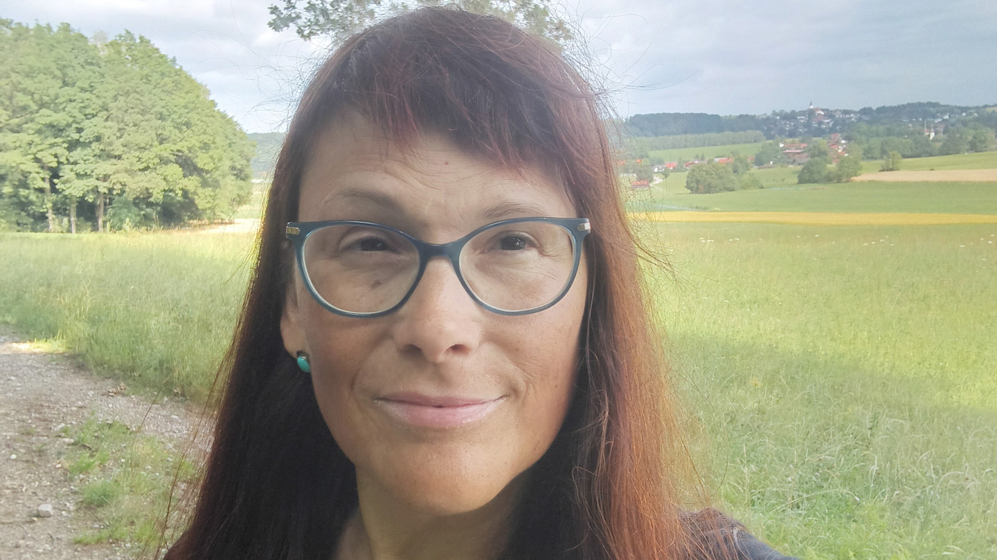 Laura Stark who has long brown hair and glasses.