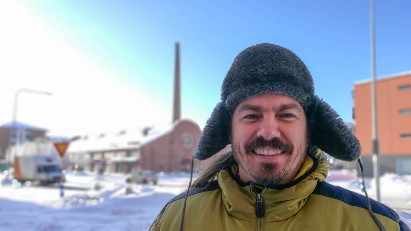 Ilja Koivisto talvisessa maisemassa. Hänellä on yllään keltainen toppatakki ja musta karvalakki.