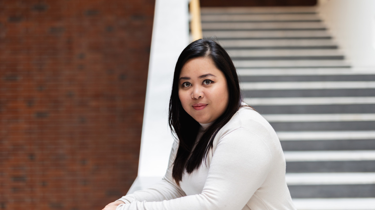 Masters degree student on the stairs at main building