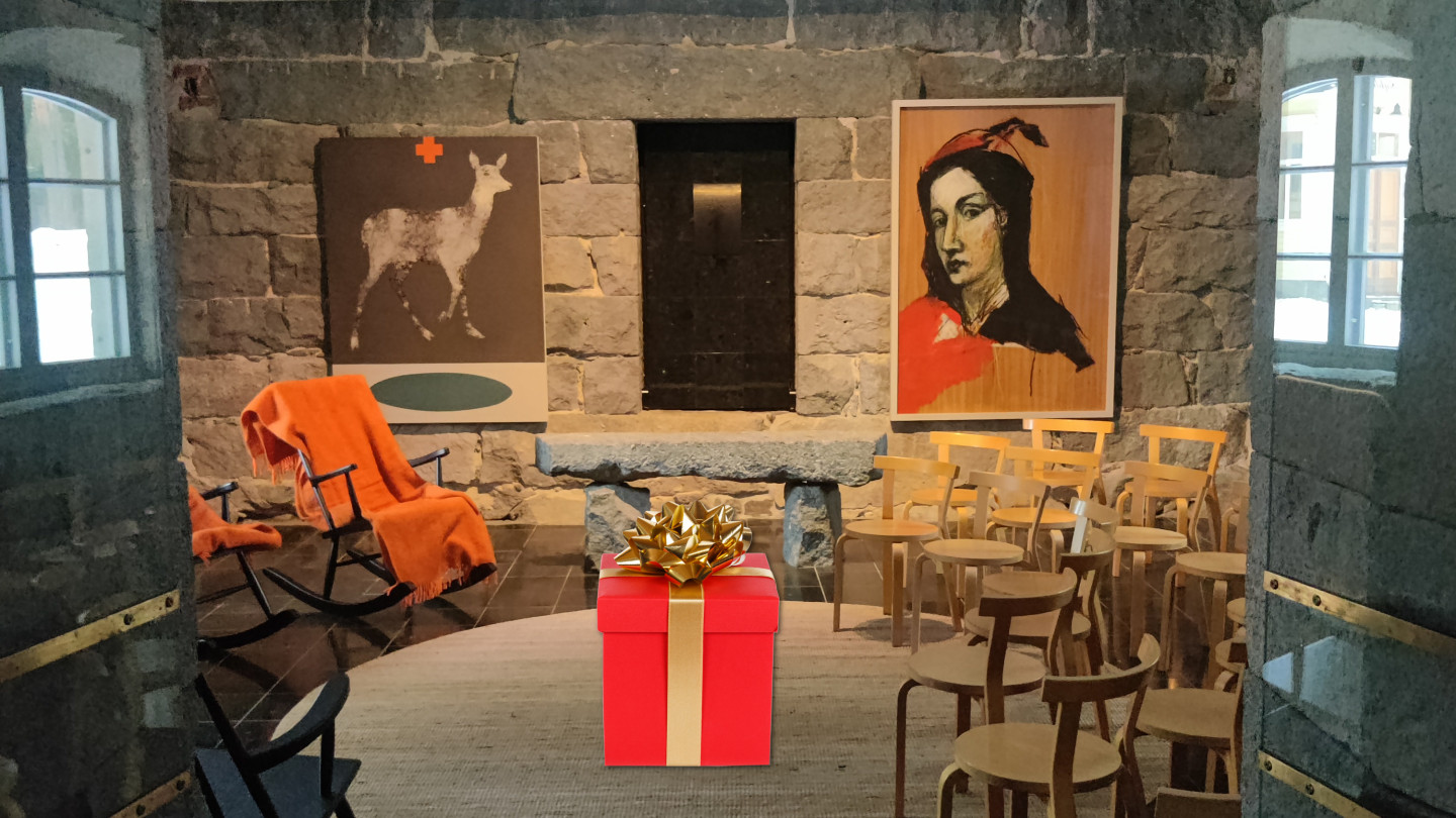 Kuvassa Seminaarinmäen Paja sisältä. Maton päällä punainen lahjapaketti.