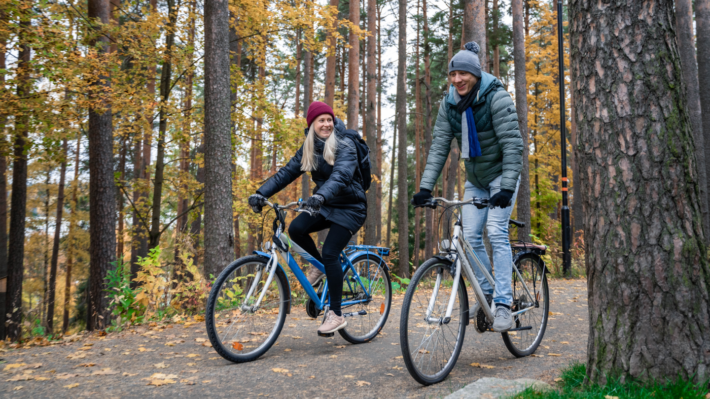 two students biking on campus in the autumn 