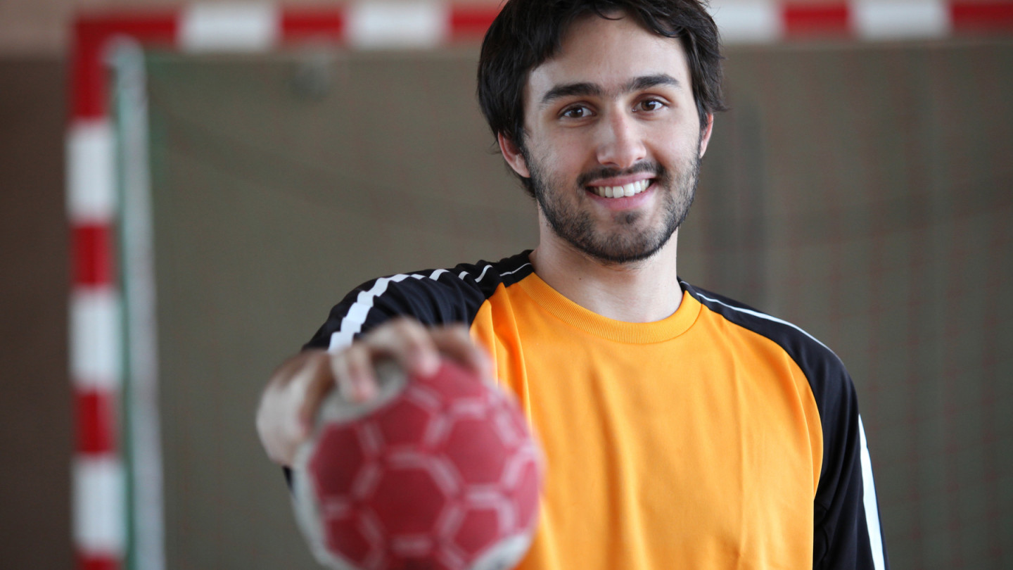 Käsipallon pelaaja lähikuvassa hymyillen