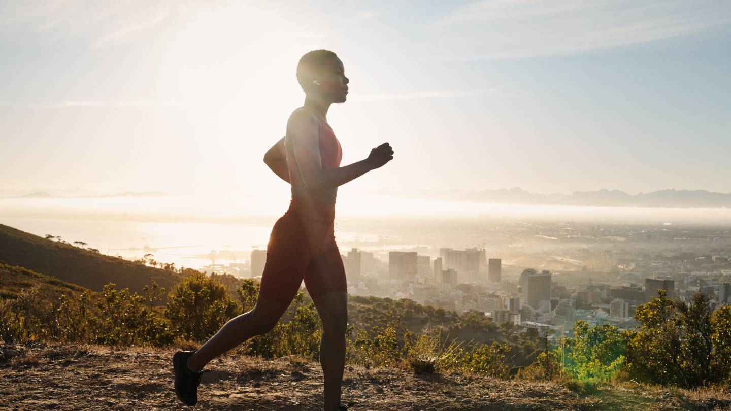 Black woman running in mountain and listening music.