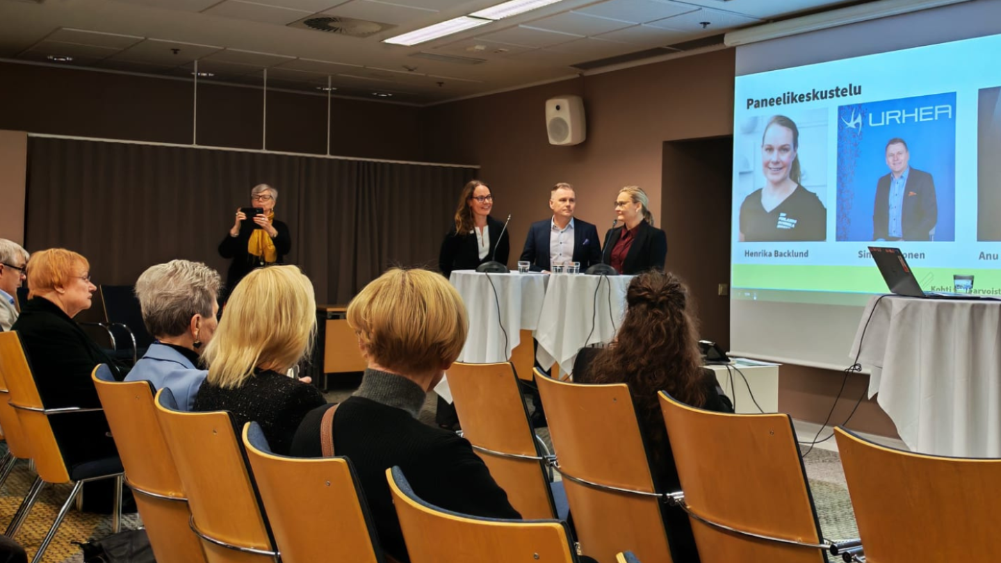 Puhujia ja yleisöä tapahtumassa