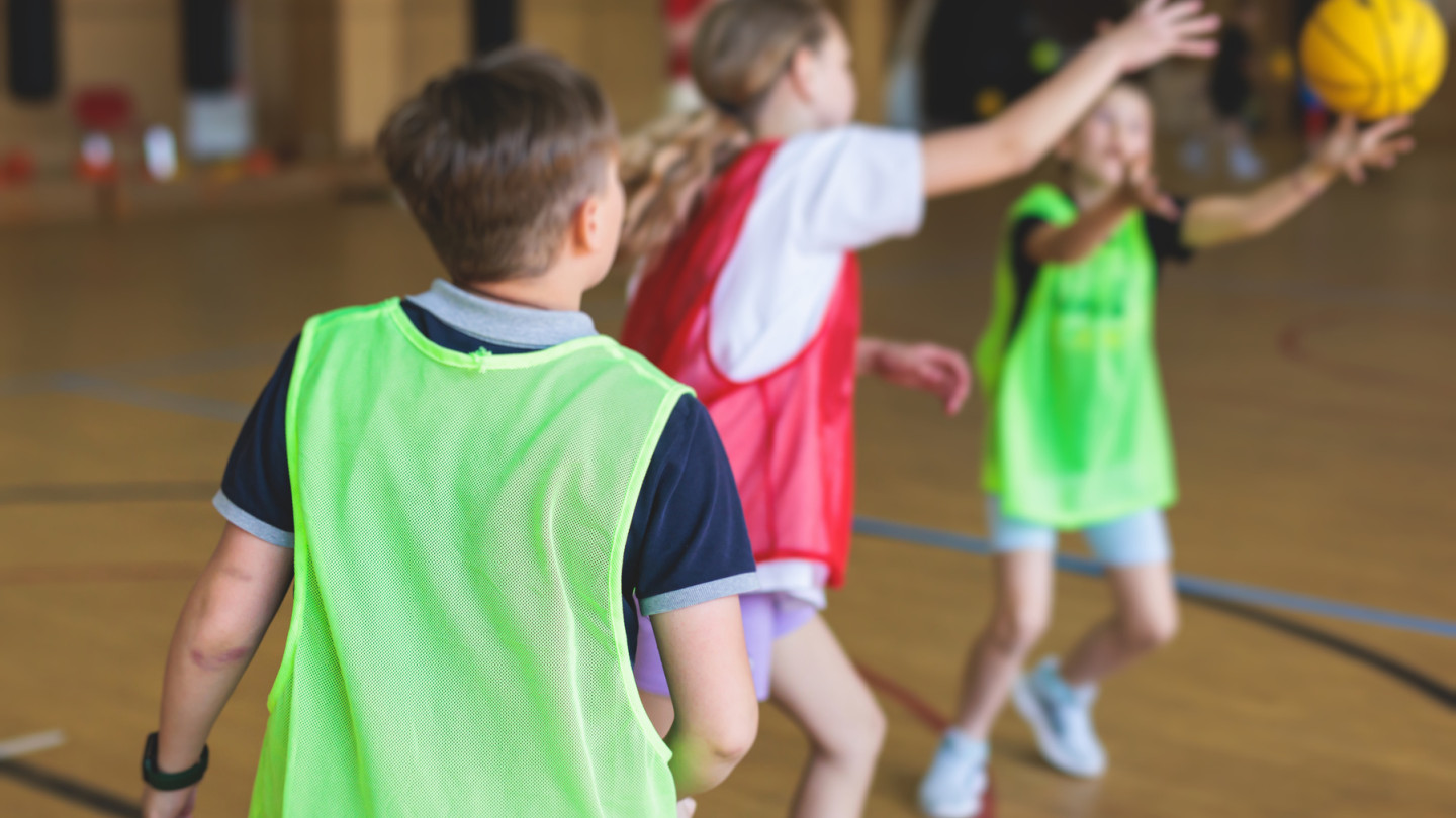 Koululaiset salissa pelaamassa