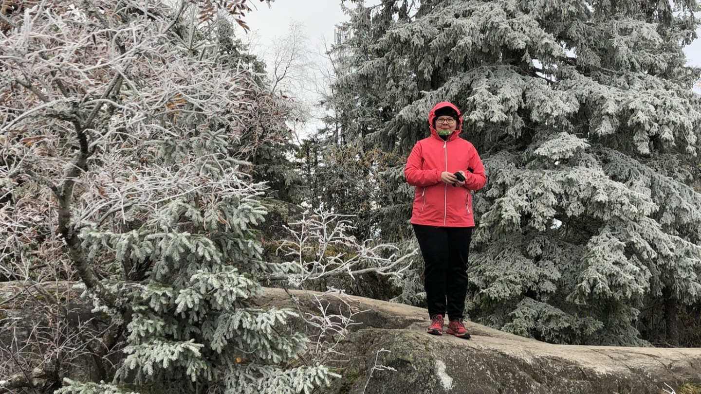 Piia Einonen talvisessa maisemassa puiden keskellä.