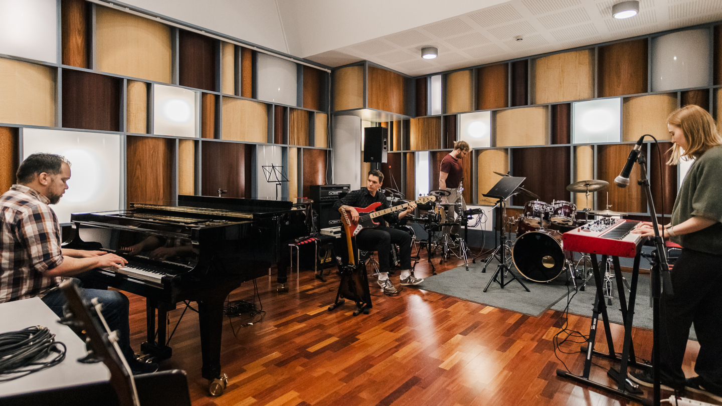 Musiikin studio, ihmisiä soittamassa.