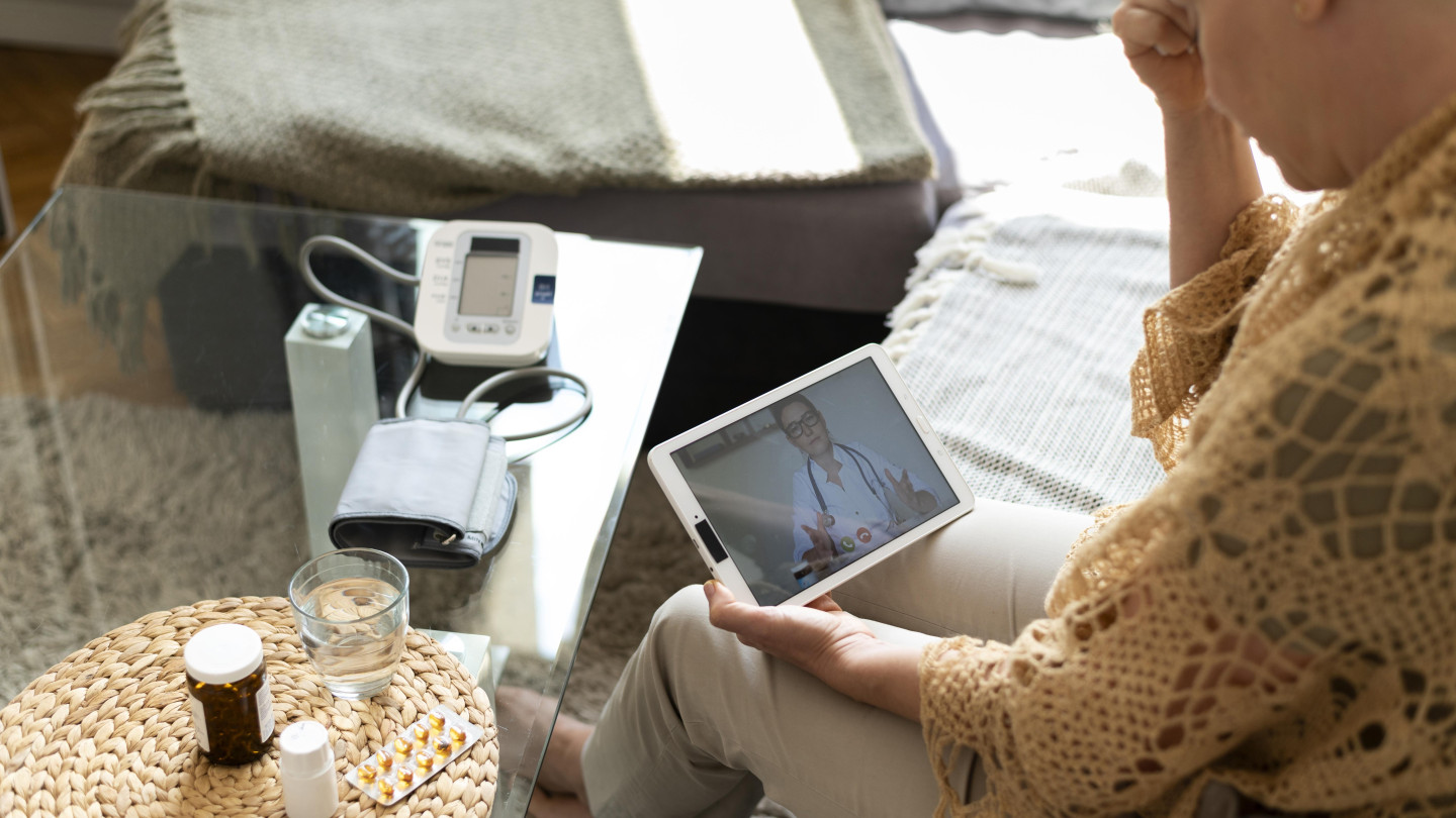 Lähikuva naisesta pitelemässä tablet-tietokonetta.