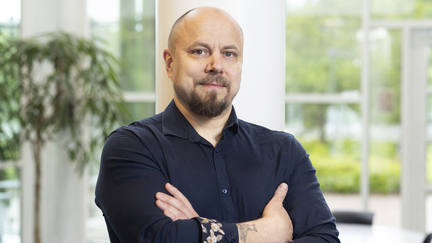 Tommi Auvinen katsoo kameraan valoisassa huoneessa.