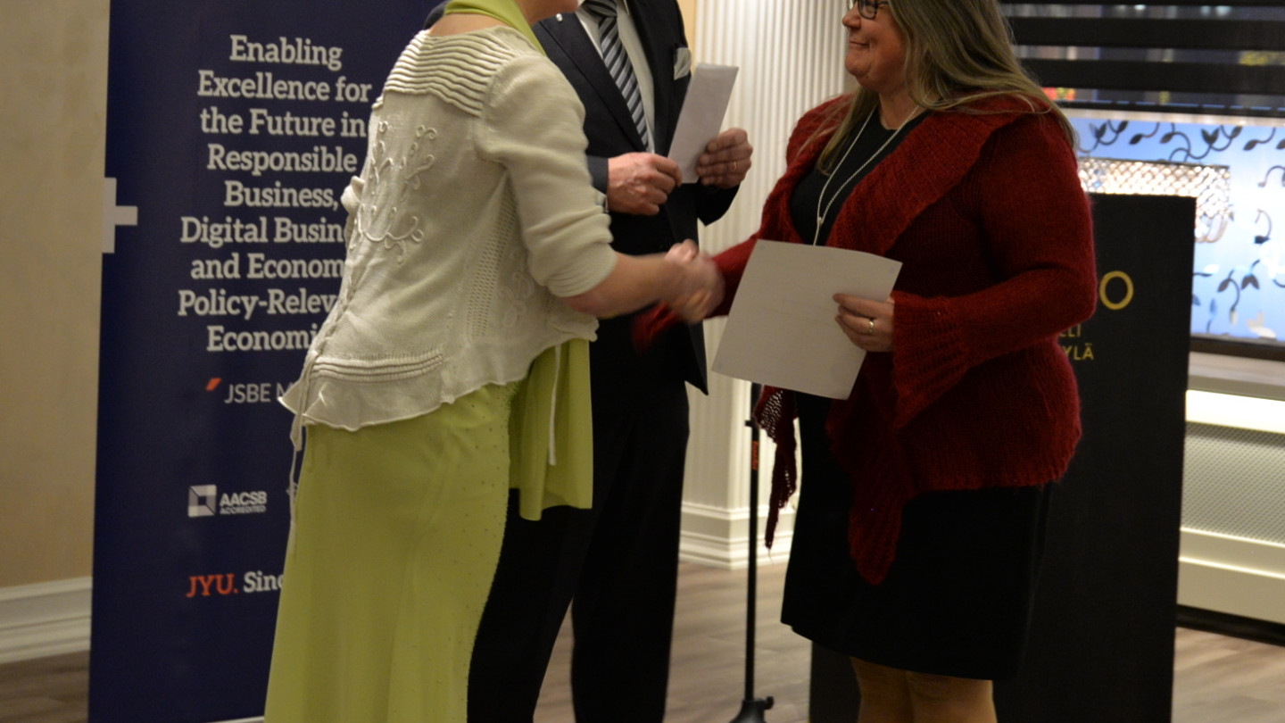 Kauppalaisseuran Pia-Maria Pohto ja Ari Routti luovuttavat stipendin kauppakorkeakoulun dekaani Hanna-Leena Pesoselle