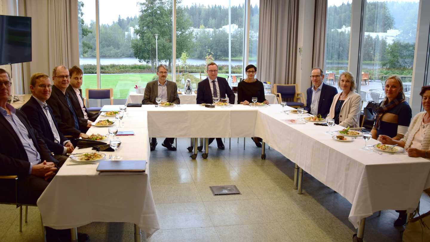 Kuvassa vasemmalta: Työelämäprofessori (kyberturvallisuus) Martti Lehto, erityisavustaja Jukka Ihanus, varadekaani (koulutus) Timo Tiihonen, varadekaani (tutkimus) Mikko Siponen, dekaani Pasi Tyrväinen, ministeri Mika Lintilä, IBM:n Suomen maajohtaja Mirva Antila, professori Pekka Neittaanmäki (laskennalliset tieteet), erityisasiantuntija Päivi Fadjukoff, työelämäprofessori (lääketiede) Pirjo Mustonen, kansanedustaja Aila Paloniemi.