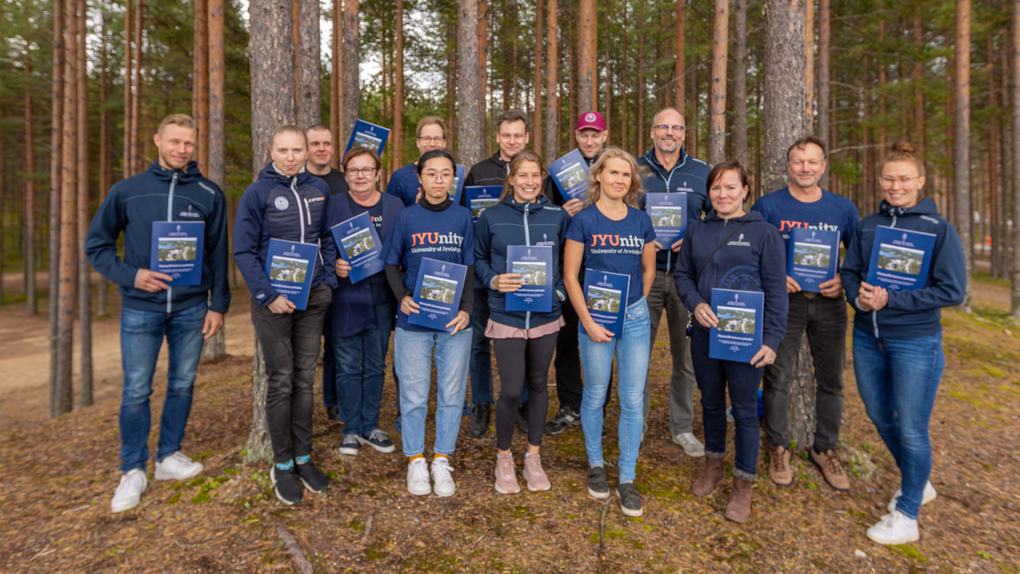 Liikuntateknologian yksikön henkilökunta poseeraa käsissään vastavalmistuneet selvitysraportit.