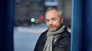 Antero Holmila kuvattuna Seminaarinmäellä Pero Luostarisen Yliopistoporttiteoksen luona.