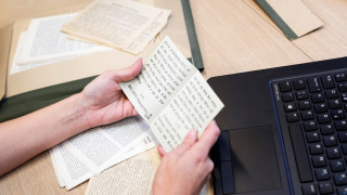 Tekstiä sisältävä paperi käsissä
