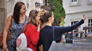 Kolme opiskelijaa ottaa selfietä