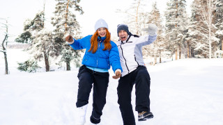 Kaksi henkilöä poseeraa lumisessa maisemassa.