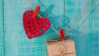 askartelusydän ja pieni paketti roikkuvat pyykkipojilla narussa