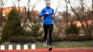 Henkilö juoksee urheilukentällä