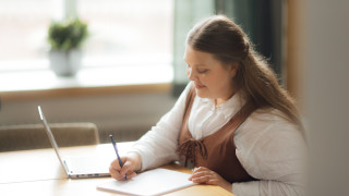 A woman is writing in a classroom