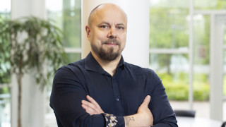 Tommi Auvinen katsoo kameraan valoisassa huoneessa.