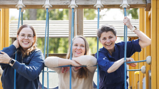 Three women on a playground climbing frame