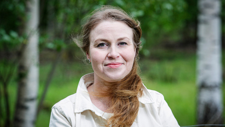 Tutkija Irene Kuhmonen kesäisessä metsämaisemassa.