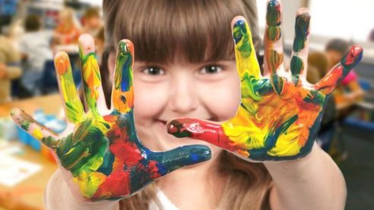 lapsen kädet sormiväreissä