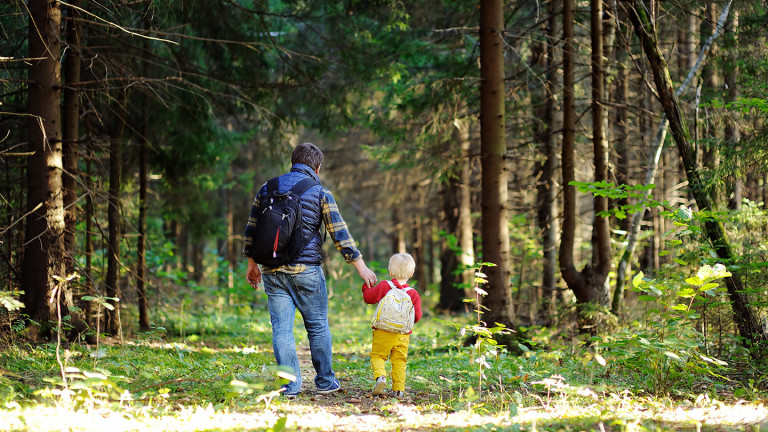 Isä ja lapsi metsäkävelyllä