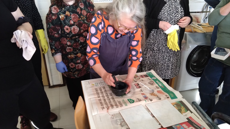 Säädellyt sävyt hankkeen kurssilla Ulla Lapiolahti näyttää kurssin osallistujille indigon jauhamista morttelilla.