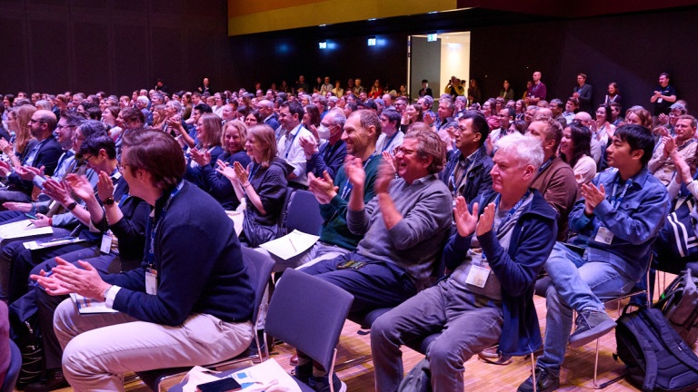 People applauding a presentation at a conference.