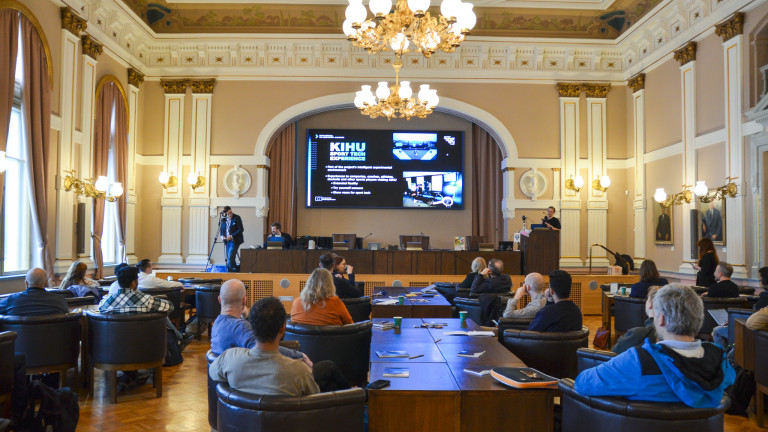 Kaupungintalon juhlasali täynnä ihmisiä ja esitys käynnissä