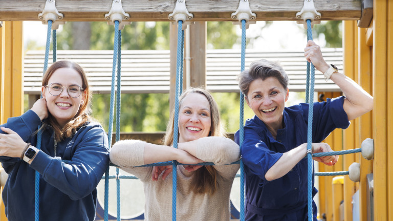 Three women on a playground climbing frame