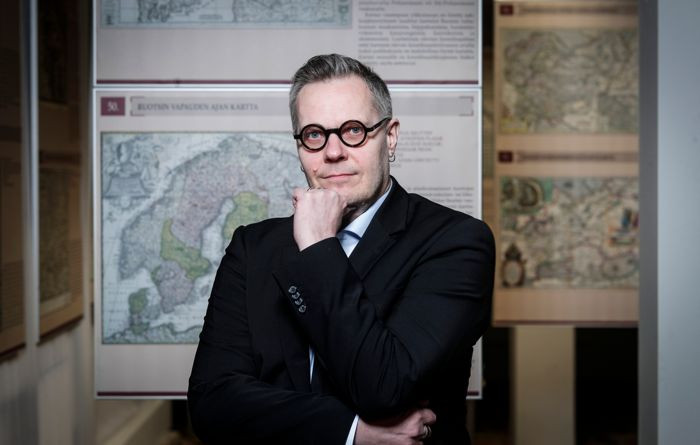 Suomen historian professori Kustaa Vilkuna mietteliään näköisenä Historican karttahuoneessa